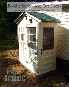 a small white shed with a green roof