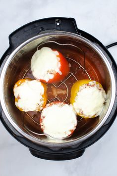 three tomatoes and cheese in an electric pressure cooker