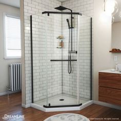 a bathroom with a walk in shower next to a white sink and wooden flooring