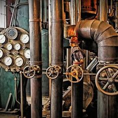 pipes and valves in an industrial setting with gauges on each side, and pressure meters to the left