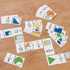 several pieces of paper with numbers and fractions on them sitting on a wooden table