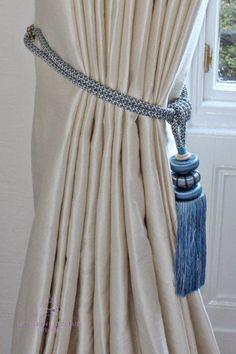 the curtain is closed and has a tasseled chain hanging from it's side