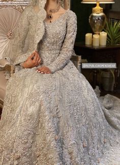 a woman in a wedding dress sitting on a chair