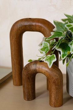 a potted plant sitting on top of a table next to two wooden letters and a vase