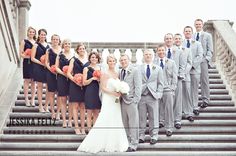 a bride and groom with their wedding party on the steps