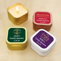 three small tins filled with candles sitting on top of a table