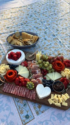 Charcuterie board layout on piece of wood. Ingredients include cheese, meats, crackers, and fruits. Cheese is cut into heart shape for the holidays. A variety of serving utensils are used. Charcuterie Board Ideas Sweet And Salty, Cutie Charcuterie Board, Sharqutary Board, 2024 Charcuterie Board Ideas, Date Charcuterie Board, Yummy Charcuterie Board, Sharcutary Board, Charcuterie Board Pretty, Galentines Party Charcuterie Board