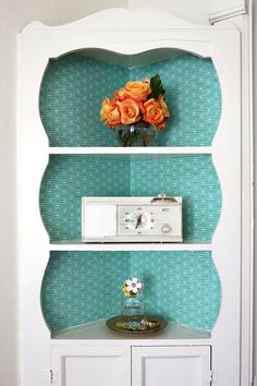 a white bookcase with flowers on top