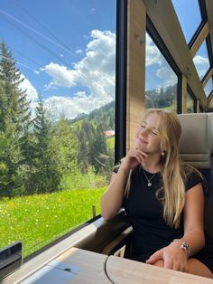 a woman sitting on a train looking out the window