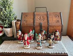 a group of figurines sitting on top of a table next to a trunk