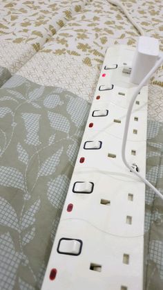 an electrical outlet is plugged into a wall outlet on a bed with floral bedspread