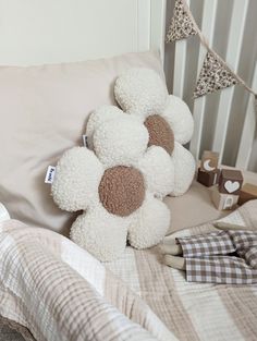 a teddy bear sitting on top of a bed next to pillows