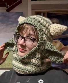 a woman wearing glasses and a crocheted animal hat on top of her head