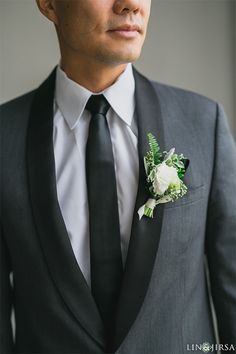 a man in a suit and tie with a boutonniere on his lapel