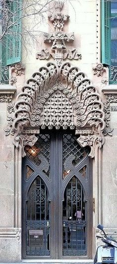 a scooter is parked in front of a building with ornate doors and windows