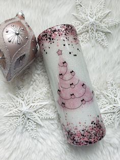 two christmas decorations are laying on a white furnishing with snowflakes in the background