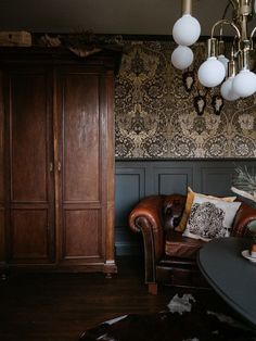 a living room filled with furniture and a chandelier hanging over the top of it