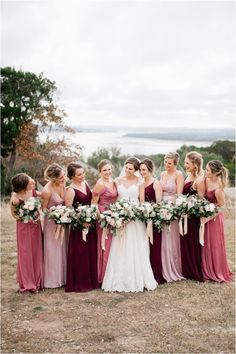 a group of women standing next to each other in front of a field with flowers