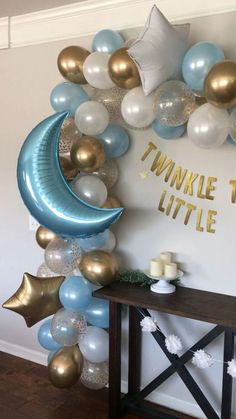 a balloon arch is decorated with blue, white and gold balloons that spell out twinkle the moon