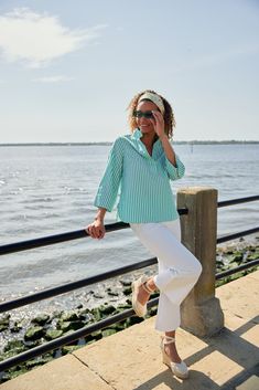 The Effie Blouse is a timeless and elegant addition to your summer staples. It features a mandarin-inspired collar, a covered button front, and a fresh green and white stripe. This crisp cotton top will take you to summer outings, evening cocktails, and everything in between. Pair it with our Blair Pants and an espadrille for a classic summer look. Generous fit - We recommend sizing down if you are between sizes. Make: High mandarin collar with button V-neckline, Pull over-the-head, Quarter leng White Blouse With Striped Collar For Spring, Spring White Blouse With Striped Collar, Spring Daywear Blouse With Striped Collar, Green Tops With Striped Collar For Spring, Chic Turquoise Blouse For Spring, Summer Green Top With Striped Collar, Green Summer Top With Striped Collar, Casual Turquoise Cotton Blouse, Beach Button-up Blouse With Button Cuffs