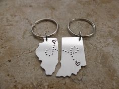 two silver state shaped key chains with hearts on them