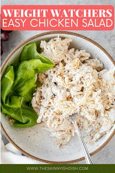 a white bowl filled with chicken salad and lettuce