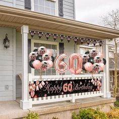 a happy 60th birthday sign with balloons and streamers on the front porch of a house