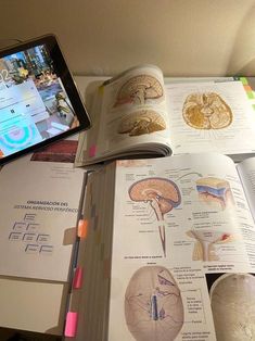 an open book sitting on top of a table next to a cell phone and tablet