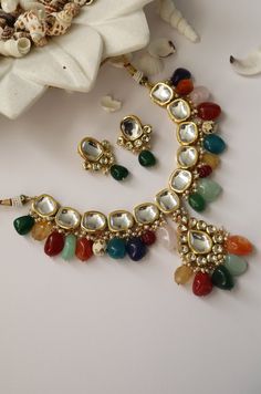 This navrattan necklace set with its pop of colors and quirky shapes is a sublime piece. The subtelty of the polki with hints of muted golden tones creates the perfect balance to create a winning look. Necklace Closure - Adjustable Dori Earrings Closure - Push Back Style Tip - This multicolored piece of art is perfect for gracing traditional funtions in full pomp and show. Navrattan itself being the traditional epitome of prosperity, wealth and status. What could be better than Handcrafted in Ja Necklace Closure, Rakhi Design, Kundan Necklace Set, Kundan Choker, Bridal Choker, Kundan Necklace, Onyx Jewelry, Pearl Choker Necklace, Kundan Necklaces