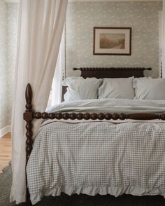 a bed with white sheets and pillows in a bedroom