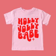 Holly Jolly Babe Christmas Shirt Feature Picture is a Pink Tee with Red Design Wash: For best results wash inside out on cold and line dry. DO NOT IRON directly on the image All our designs are printed with high quality heat transfer vinyl. The designs are applied using a professional commercial grade heat press and are made to last. All items are made to order in the order in which they are received so please allow 5 business days for your order to be shipped out. Business days include: Monday Cute Red T-shirt For Winter, Cute Red Winter T-shirt, Playful Red Christmas Tops, Playful Cotton Holiday Tops, Cute Red Holiday Tops, Playful Cotton Tops For The Holiday Season, Pink Cotton Top For Holiday, Playful Cotton Christmas Top, Pink Cotton Tops For Holiday