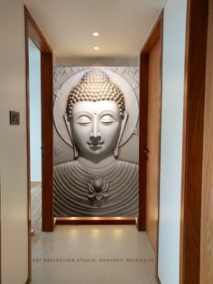 a white buddha statue sitting in the middle of a hallway next to a wall with a light on it