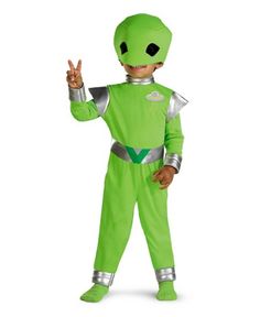 a young boy in a green costume is making the v sign with his hand while standing up