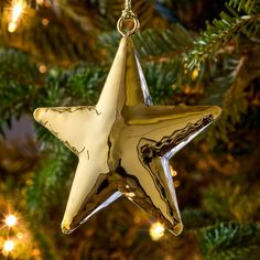 a glass star ornament hanging from a christmas tree