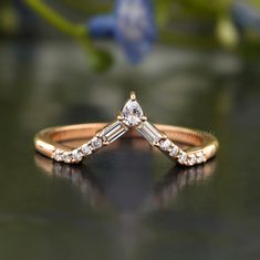 a gold ring with two baguettes and diamonds on it sitting on a table