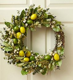 a wreath with lemons and greenery hangs on the front door to welcome guests