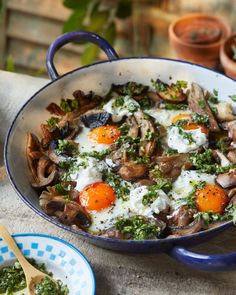 a pan filled with mushrooms and eggs on top of a table