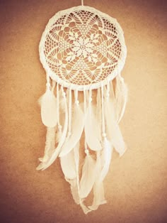 a white dream catcher hanging on the wall with words catch the dream written below it