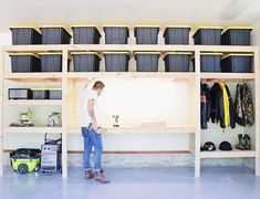 a man standing in front of a shelf filled with clothes and other items on it