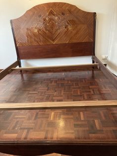 a bed with wooden headboard and foot board on top of wood flooring in a bedroom