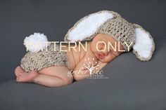 a newborn baby wearing a crochet bunny hat and diaper is laying down