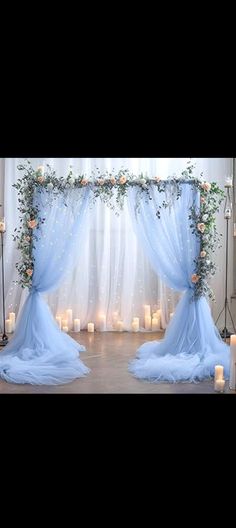 a blue wedding arch decorated with flowers and candles