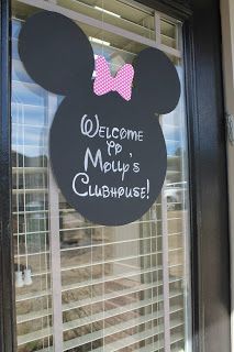 a mickey mouse sign is hanging on the front door