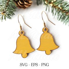 wooden earrings with a bell on it and pine cones in the background, christmas ornament