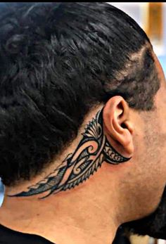 a man with a black and grey tattoo on his neck is looking into the distance