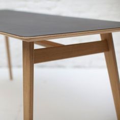 a wooden table with a black top on a white floor