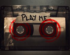 an audio tape with the word play me written on it and two red circles in front of it