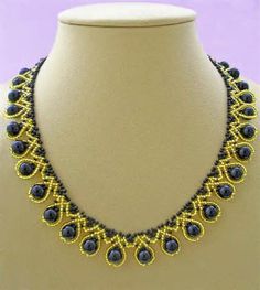 a necklace with blue beads is displayed on a mannequin's neckline