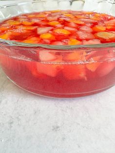 a glass dish filled with fruit sitting on top of a counter