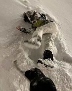 a snowboarder is falling down in the snow with his feet on the ground